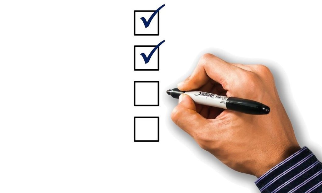 The hand of an Accessibility Advocate checking boxes on a checklist